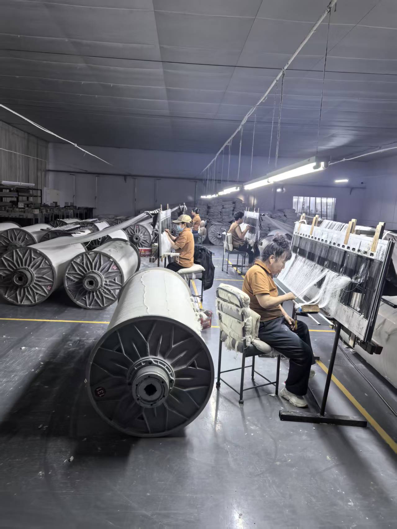 An operator preparing yarns at the loom setup station
